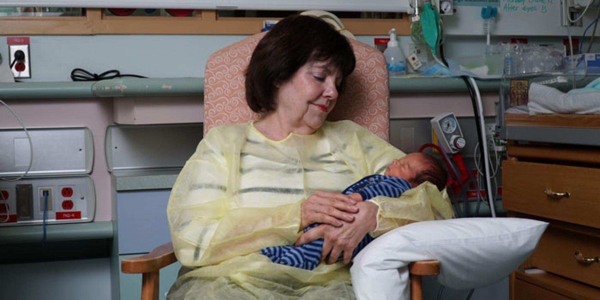 Nancy Simmons, Special Care Nursery volunteer, holds a newborn in her arms like she does every Monday during her shift.