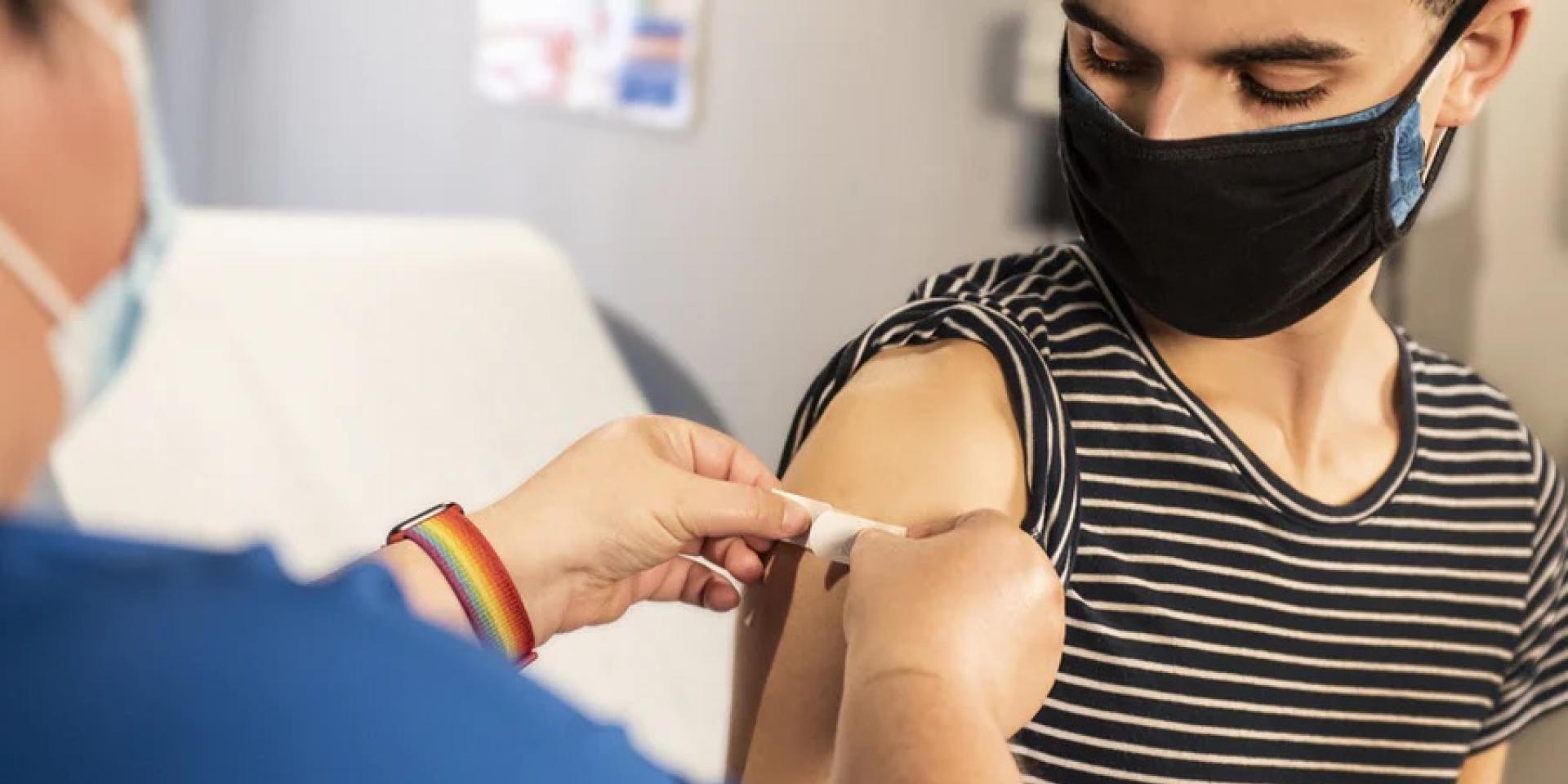 A healthcare worker applies a bandage to a patient after their flu vaccine.