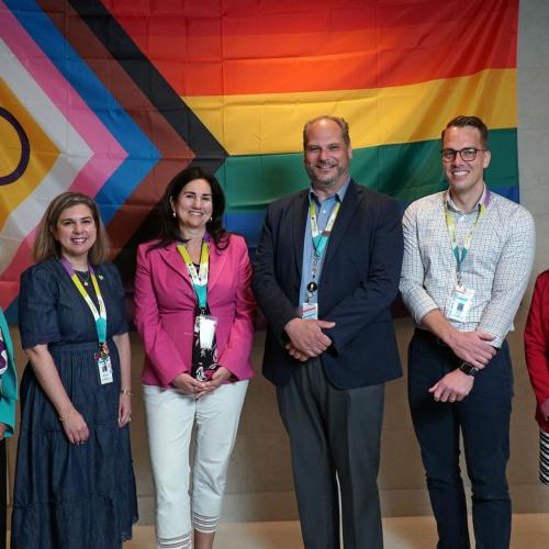 Members of the MGH Executive Team with the Progress Pride Flag in the Thomson Centre Lobby in June 2024. 