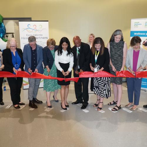 Melanie Kohn with staff and leaders from partner organizations, community members and government representatives at a ribbon cutting at the grand opening of the Thorncliffe Park Youth Wellness Hub in July 2023. 