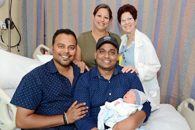 New parents Asish Purushan and Krishneel Lall with baby Sidharth, surrogate Mazyline McCarthy and obstetrician and gynecologist Dr. Brenda Woods