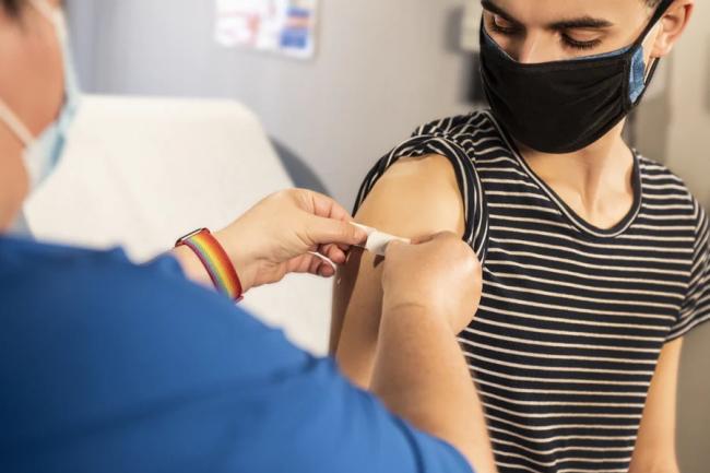 A healthcare worker applies a bandage to a patient after their flu vaccine.