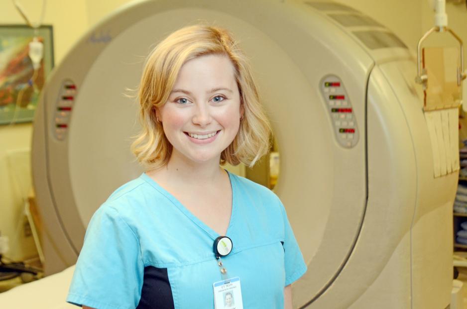 Medical Radiation Technologist standing in front for CT scan machine