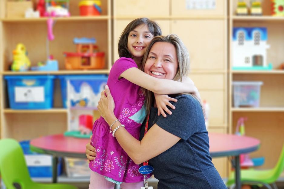 Diana Tustin and patient Chelsea Doucette Child life specialist Diana Tustin hugging patient Chelsea