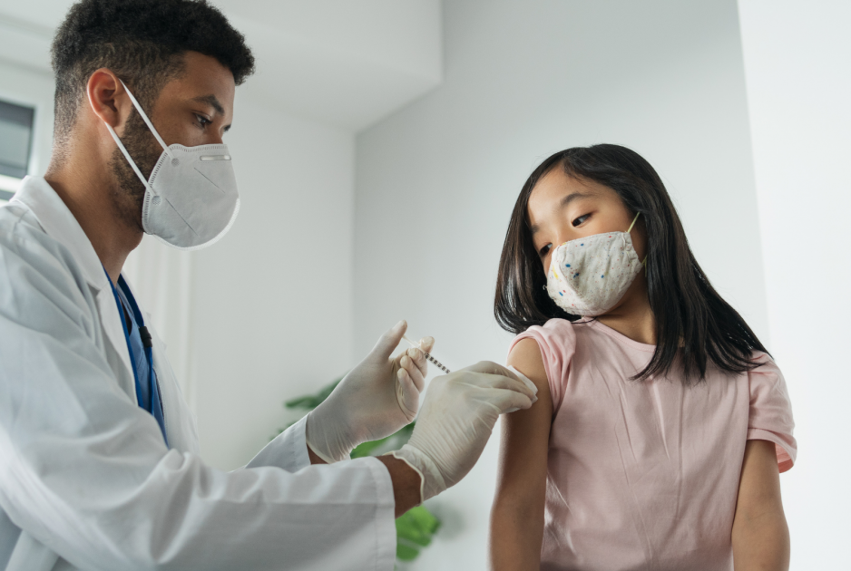 A child is vaccinated by a healthcare worker. A child is vaccinated by a healthcare worker.