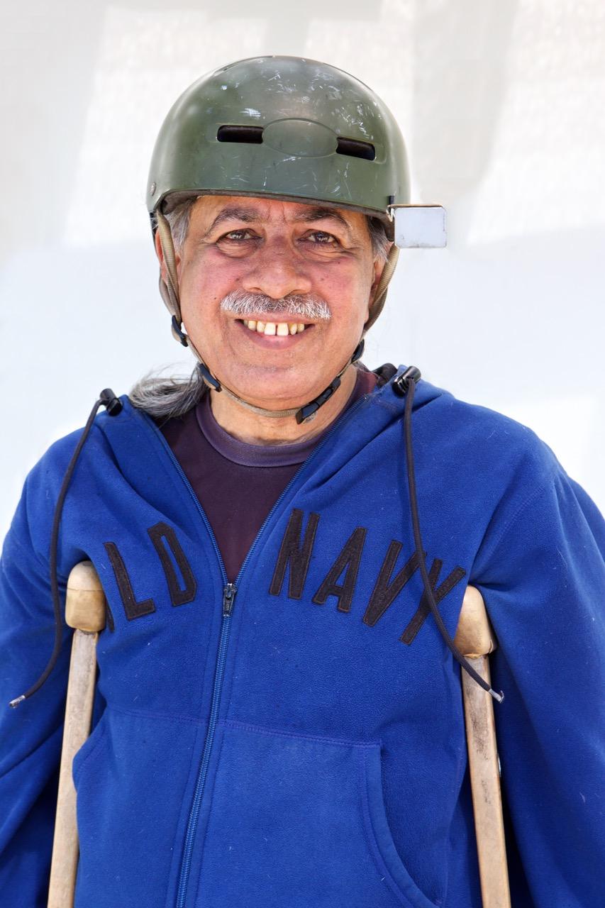 A man wearing a blue sweater and smiling