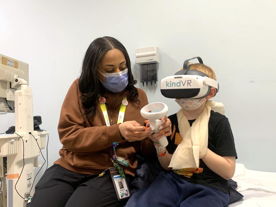 A Child Life Specialist helps a paediatric patient with a virtual reality activity.