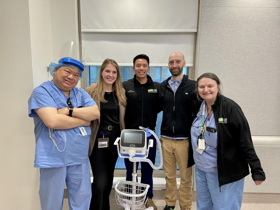 Healthcare workers smiling and standing around the Synclara cough machine. Healthcare workers smiling and standing around the Synclara cough machine.